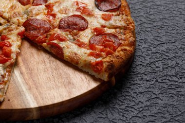 Siyah desenli arka planda Pepperoni pizza. İtalyan gıda konsepti.