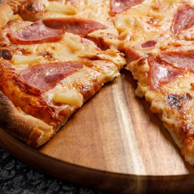 Siyah desenli arka planda Pepperoni pizza. İtalyan yemeği konsepti. Yakın plan..