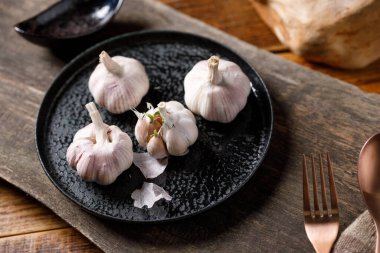 Tahta masadaki sarımsak soğanlarını yakın plan çek..