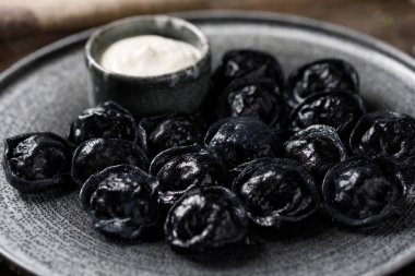 Geleneksel Rus köfteleri, siyah hamur için mürekkeple boyanmış. Tahtada hayat devam ediyor.