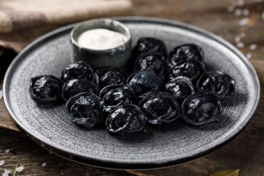 Geleneksel Rus köfteleri, siyah hamur için mürekkeple boyanmış. Tahtada hayat devam ediyor.