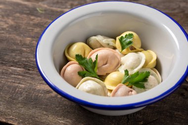 Geleneksel Rus hamur köfteleri çok renkli hamurdan yapılır. Tahtadaki hamur köfteleri diş minesi tabağında..