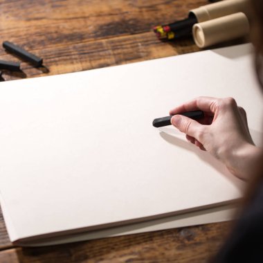 Ressamın boş bir sayfadaki yakın görüntüsü. El bir kalem tutar ve çizer..