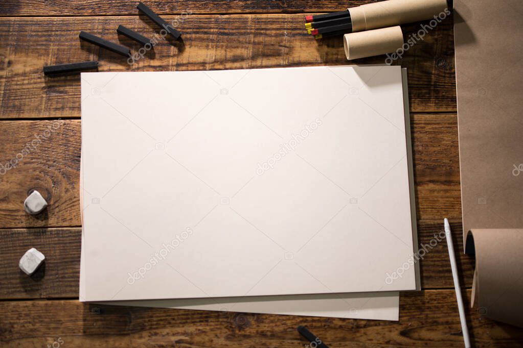 Close-up view of a painter on a white sheet. A man holds a pencil and draws.