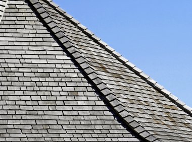 Weathered Cedar shingles on roof - blue sky background