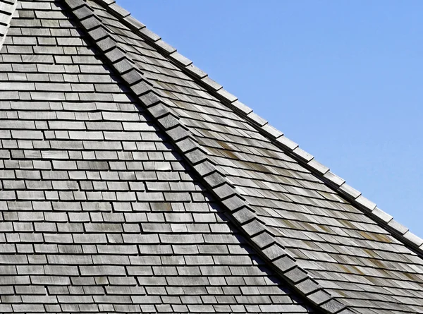 Weathered Cedar shingles on roof - blue sky background