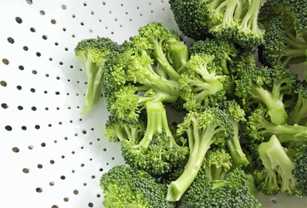 Freshly washed and cut up Broccoli in white Colander - ready to eat — Stock Photo, Image