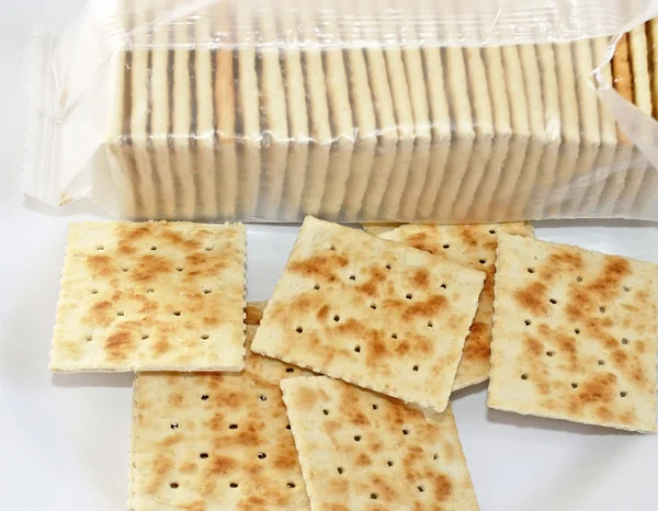 Gevrek soda krakeri plaka üzerinde. Arka planda açık paketi