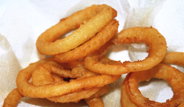 Golden brown deep fried Anéis de cebola definidos em toalha de papel para absorver graxa — Fotografia de Stock