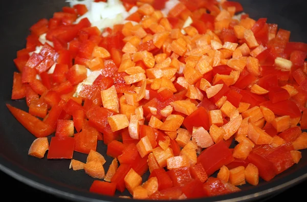 Kockára vágott piros paprikát, a sárgarépát és a hagymát egy nem bottal serpenyőben főzés készen — Stock Fotó