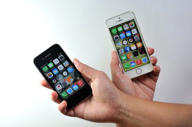 Beyaz Apple iphone 5'ler ve siyah Apple iphone 4s tutan kadın