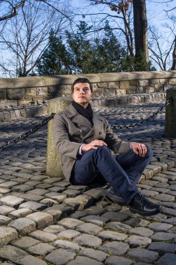 Genç bir adam umarım dışarıda bekliyor, yukarı bakıyor.