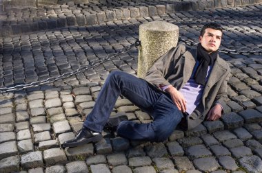 Genç bir adam yerde yatıyor, umarım yukarı bakıyor.