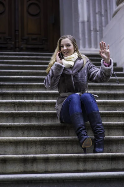 Μια Νεαρή Γυναίκα Κάθεται Στις Σκάλες Μιλώντας Στο Τηλέφωνο Και — Φωτογραφία Αρχείου