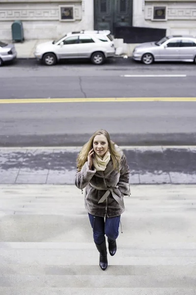Telefonda Konuşan Genç Bir Kadın Neşeyle Merdivenlerden Çıkıyor — Stok fotoğraf
