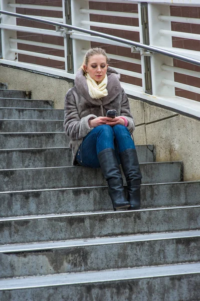 Genç Bir Kadın Merdivenlerde Oturuyor Telefonda Mesajlaşıyor — Stok fotoğraf