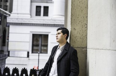 Genç bir işadamı ofis binasının dışında dikilip...