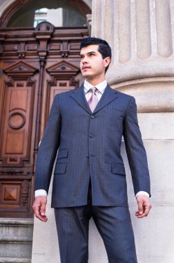 Resmi olarak genç bir iş adamını giydirmek bir ofis binasının önünde dikilip ileriye bakmaktır. Takım elbise yeni bir tarz.