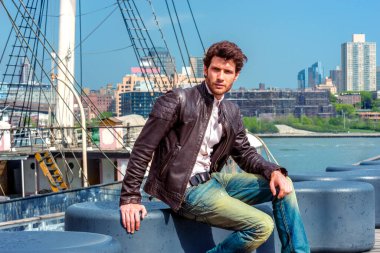 Avrupalı bir işadamı New York 'ta seyahat ediyor. Siyah deri ceket ve kot pantolon giyen, sakallı genç bir adam limandaki bankta oturuyor, somurtkan, üzgün ve düşünüyor. Arka planda bir tekne.