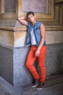 Genç bir adam dışarıda duruyor ve sana bakıyor.