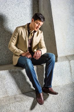 Genç yakışıklı bir adam oturuyor ve saatine bakıyor..