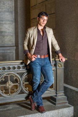 Korkulukların orada genç bir işadamı duruyor ve sana bakıyor..