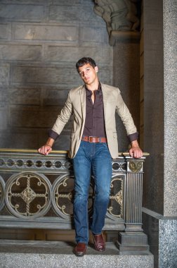 Korkulukların orada genç bir işadamı duruyor ve sana bakıyor..