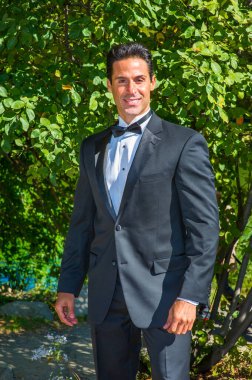 Profesyonel bir yönetici siyah bir smokin giyer, aşağı bakar ve düşünür.