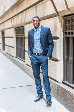 Genç bir siyahi işadamı bir caddenin penceresinin önünde dikiliyor ve nefes alıyor.