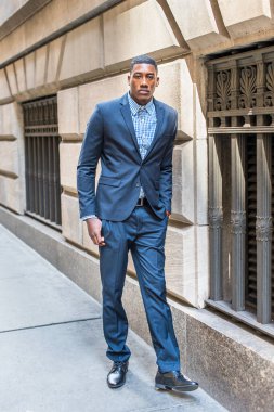 Genç bir siyahi işadamı bir caddenin penceresinin önünde dikiliyor ve nefes alıyor.