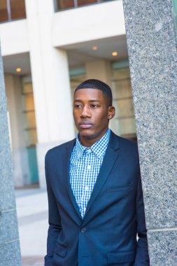 Genç ve yakışıklı bir siyah adam kendinden emin bir şekilde ileriye bakıyor.