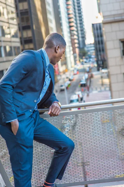若い黒人実業家がバルコニーに立って手すりの上に曲げ 通りを見下ろし リラックスしています — ストック写真