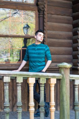 Genç yakışıklı bir adam pencerenin yanında durup düşünüyor.