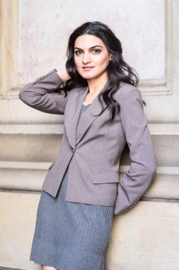 Genç bir iş kadını dışarıda dikiliyor ve nefes alıyor.