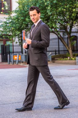 Resmi olarak giyinmiş genç bir iş adamı sana gülümsüyor ve yürüyor.