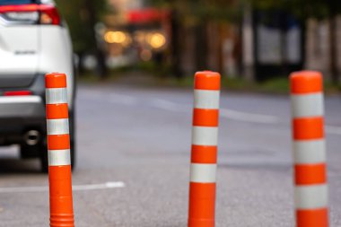 Kırmızı ve beyaz trafik bollard yaya bölgesinden ayrı araba trafiği, arka planda arabalarla bulanık cadde
