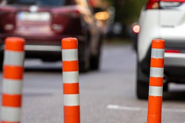 Kırmızı ve beyaz trafik bollard yaya bölgesinden ayrı araba trafiği, arka planda arabalarla bulanık cadde