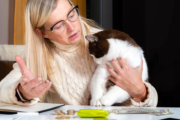 Evden çalışan orta yaşlı kadın muhasebeci. Kucağına kedi alıp onunla konuşuyor. Yaşam tarzı konsepti.