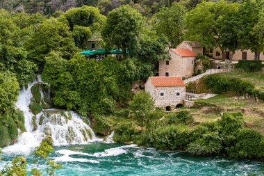Krka Ulusal Parkı Şelaleleri ve turuncu kiremit çatılı taş değirmeni binası, Dalmaçya, Hırvatistan