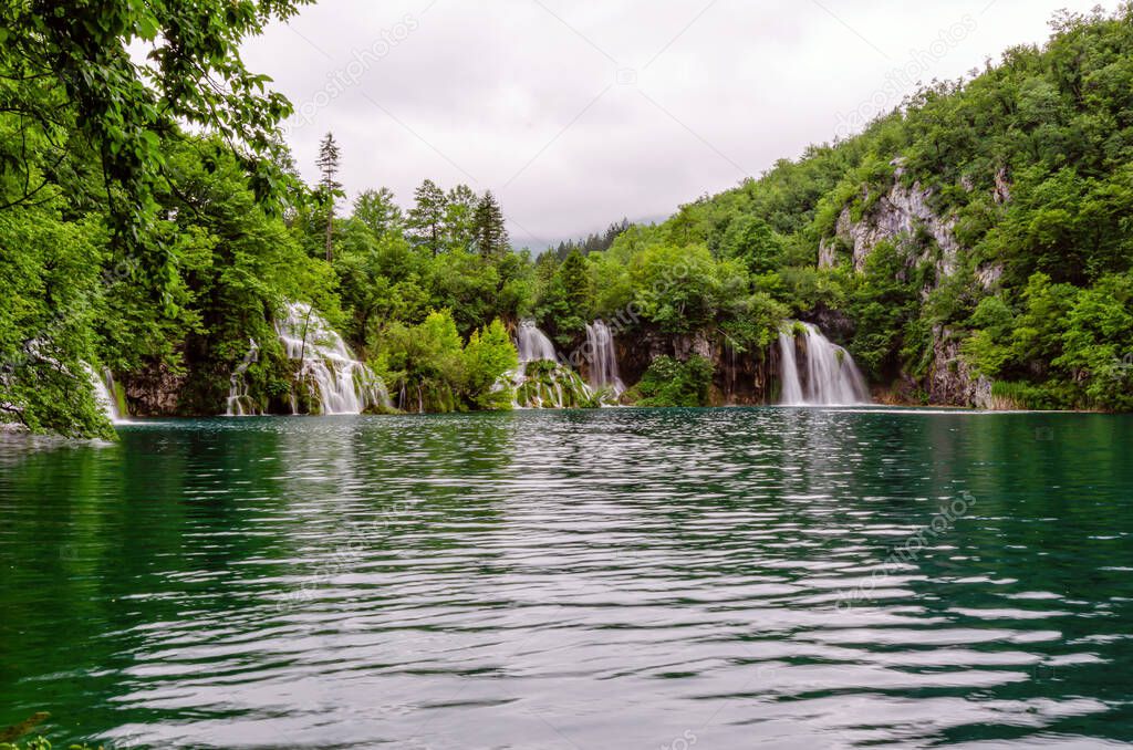 Beautiful waterfall and blue limpid lake in Plitvice Lakes National Park, Dalmatia, Croatia