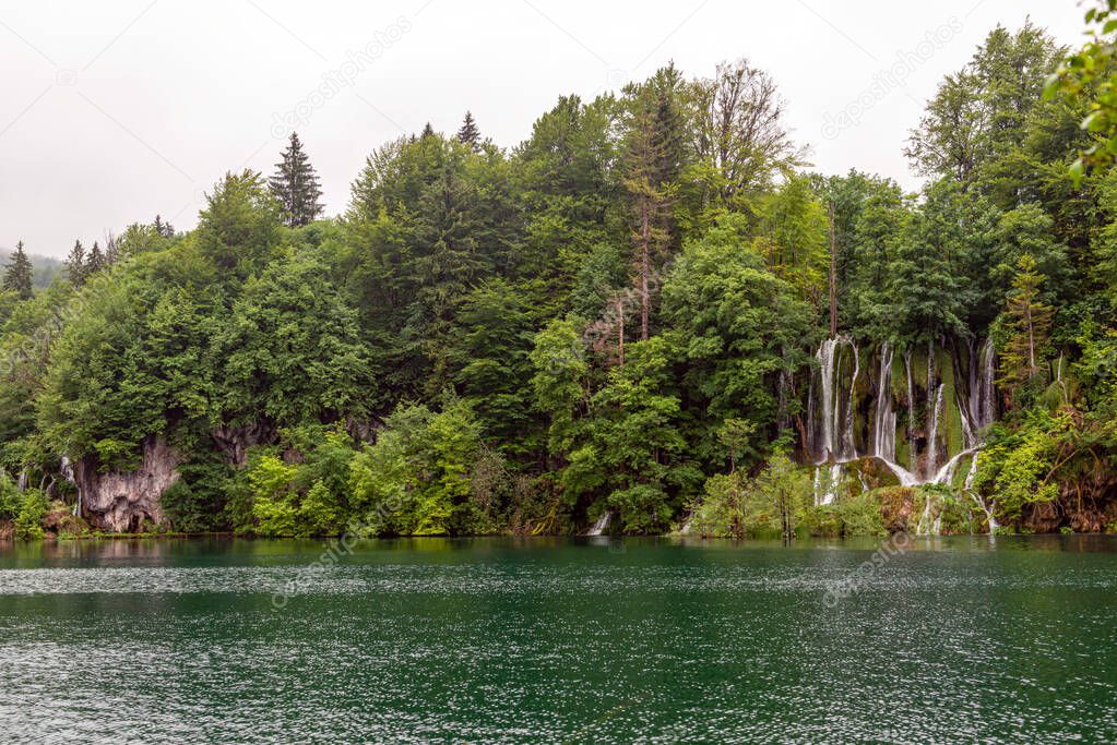 Beautiful waterfall and blue limpid lake in Plitvice Lakes National Park, Dalmatia, Croatia