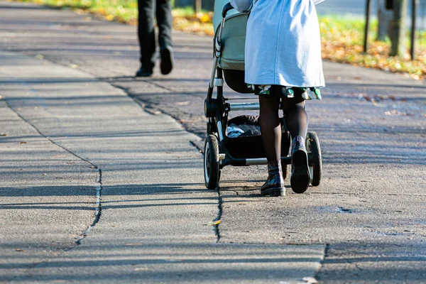 Ludzie Spacerujący Asfaltowym Chodniku Słoneczny Dzień Nogi Kobiety Wózek Zacienionym — Zdjęcie stockowe