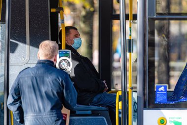 Riga, Letonya - 6 Kasım 2020: Toplu taşımacılıkta tıbbi maskeli insanlar, koronavirüs koruma kavramı