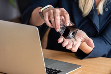 Bir ofis çalışanı elinde bir konteynırdan ataç doldurur, yakın plan.