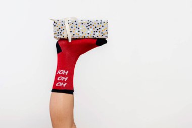 Kırmızı Noel çorapları içinde ince kadın bacakları. Hediye kutusu beyaz, yakın plan.