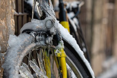 Buz ve buz saçaklarıyla kaplı bir bisikletin yakın çekimi