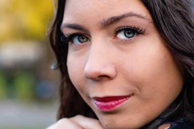 Koyu saçlı, güzel bir genç kadının yüzüne yakın çekim.