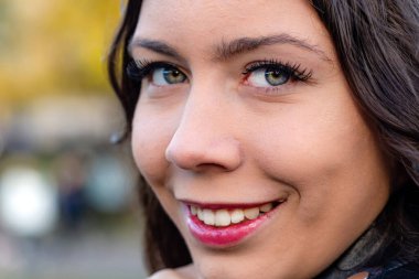 Koyu saçlı, güzel bir genç kadının yüzüne yakın çekim.