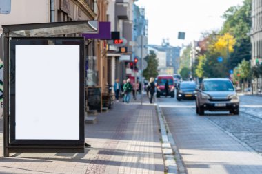 Şehir caddesindeki otobüs durağında dikey beyaz ilan panosu, maket