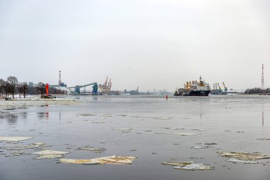 Riga, Letonya - 9 Şubat 2021: Birden fazla römorkör limandan çıkmak için kargo gemisine yardım ediyor.